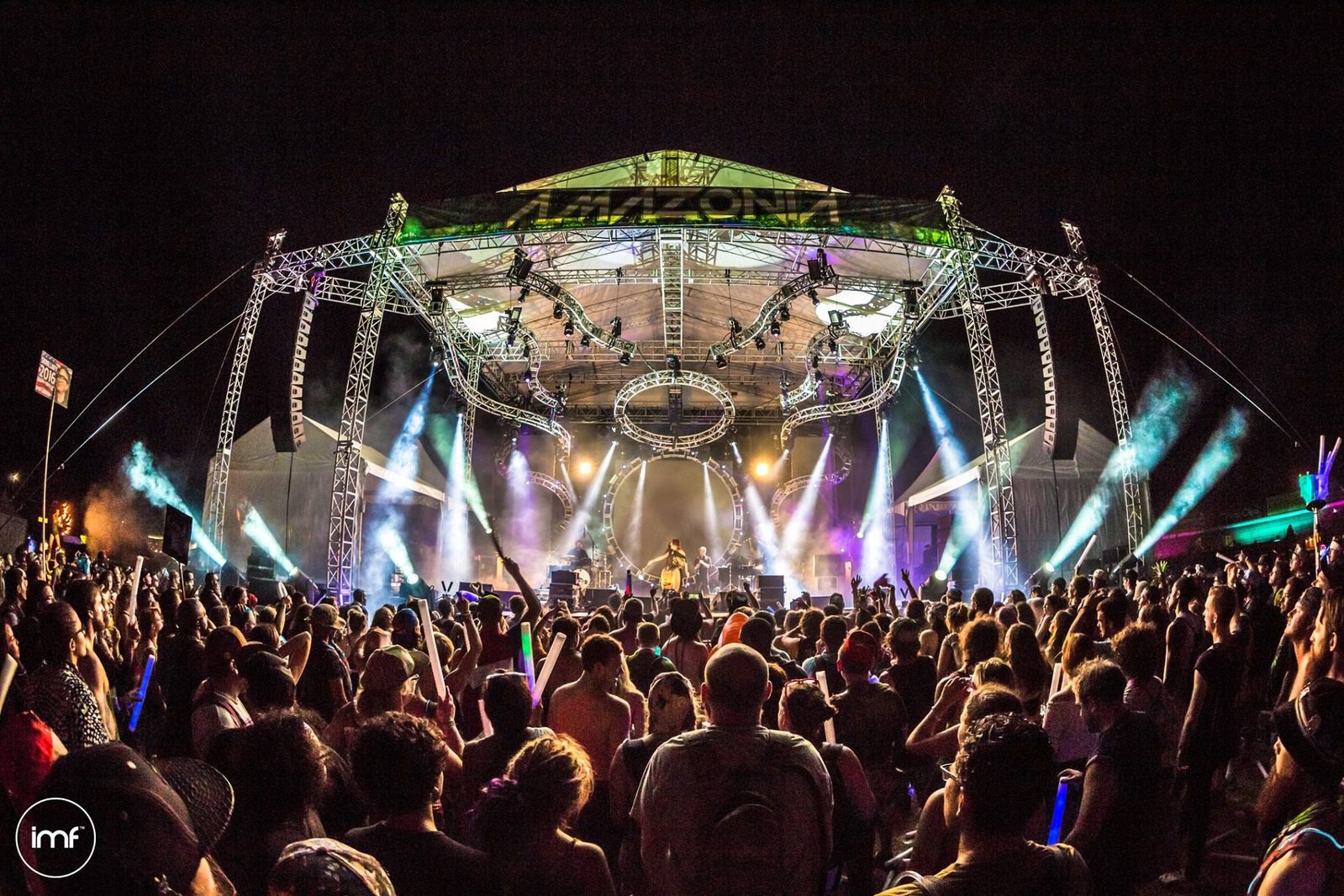 Outdoor concert stage with custom truss roof system, professional lighting rig, and crowd at a music festival